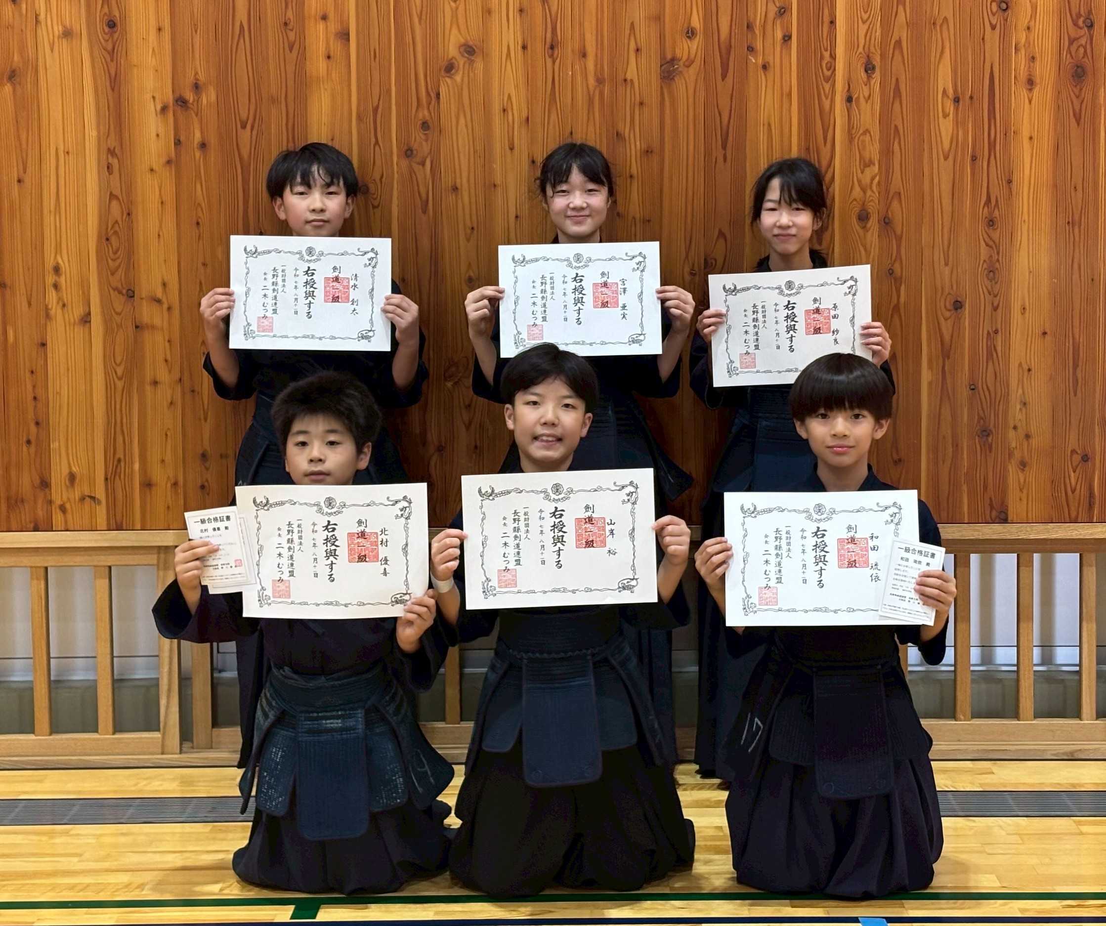 級審査で合格証を見せている子供たち